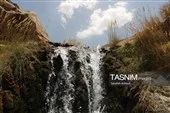 جریان زلال آبشار فیض‌آباد راور از میان سنگ‌ها